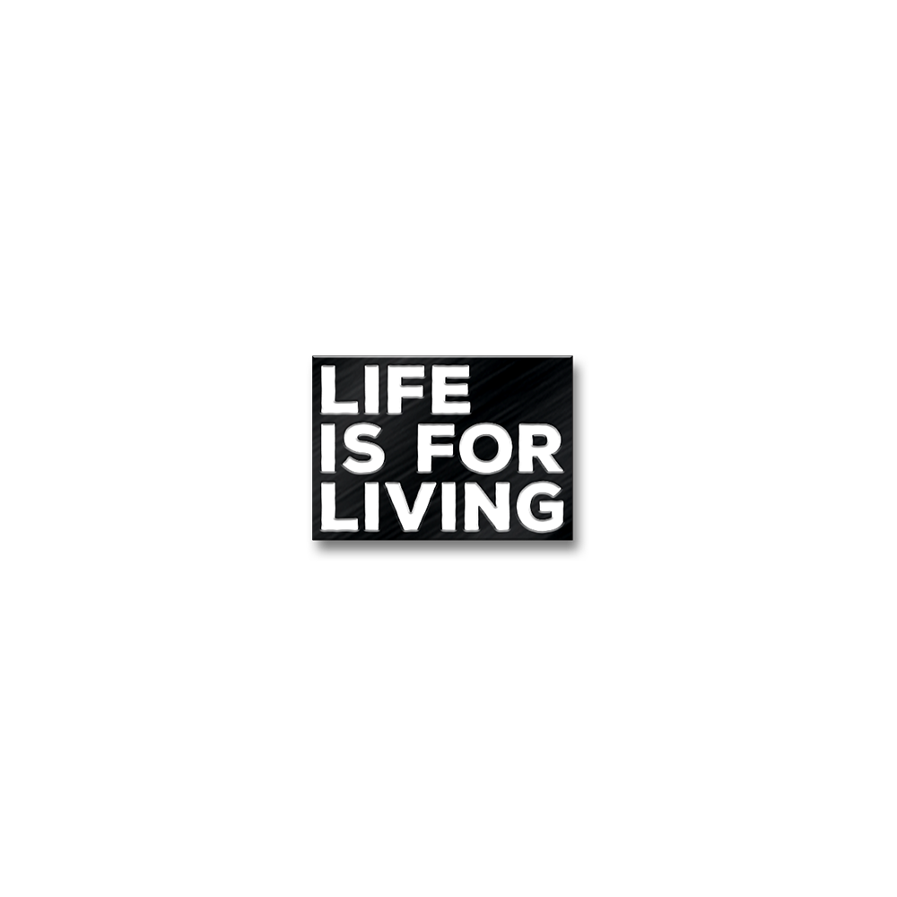 Black rectangular sign with white text reading ’LIFE IS FOR LIVING’.