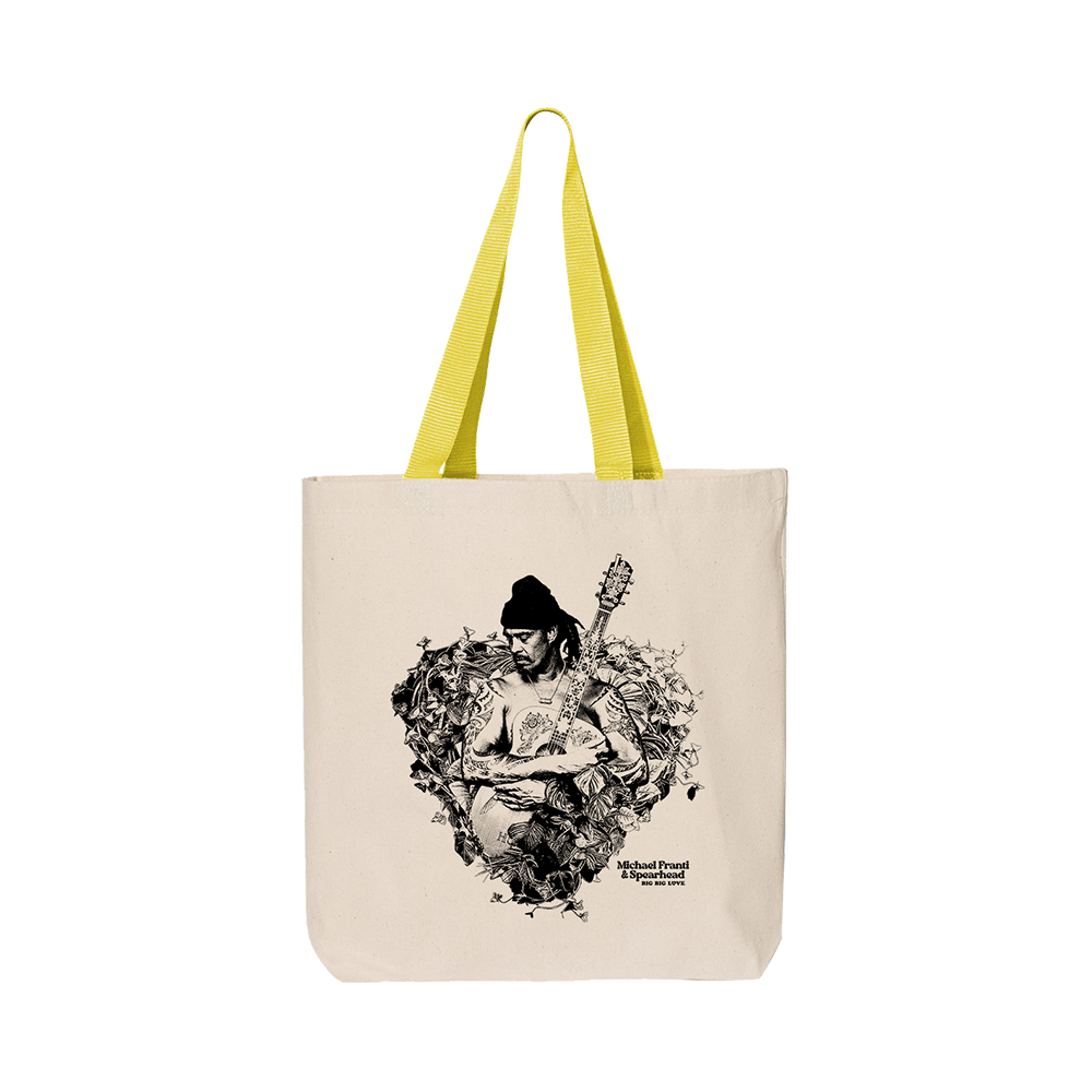 Canvas tote bag with yellow handles featuring a black and white artistic print of a musician playing guitar.