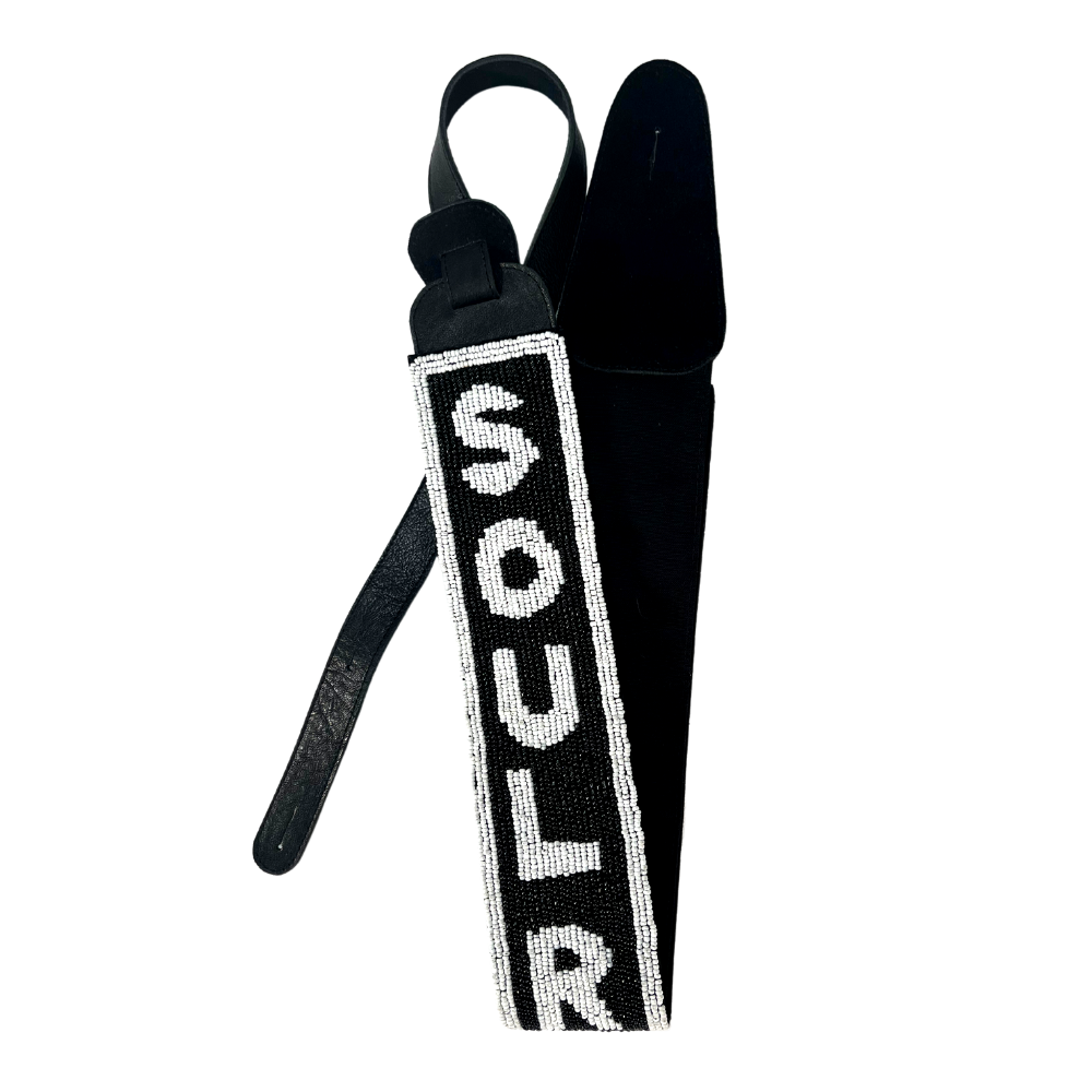 Guitar strap with ’SOUL R’ spelled out in white beads on a black background.