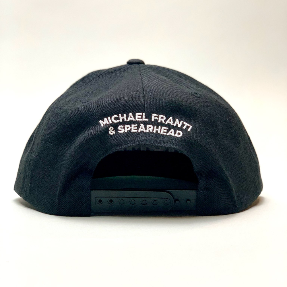 Black baseball cap with ’MICHAEL FRANTI & SPEARHEAD’ embroidered on the back.