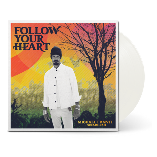 Album cover for ’Follow Your Heart’ by Michael Franti + Spearhead featuring a man in white clothing against a colorful sunset backdrop.
