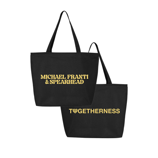 Black tote bag with gold text featuring ’Michael Franti & Spearhead’ on one side and ’Togetherness’ on the other.